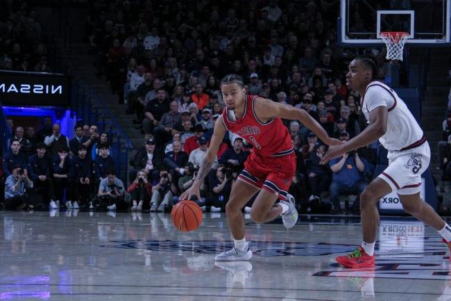 Men's basketball player Mikey Lewis drives against Gonzaga in the game that won the 2024-25 WCC regulars season championship for the Gaels